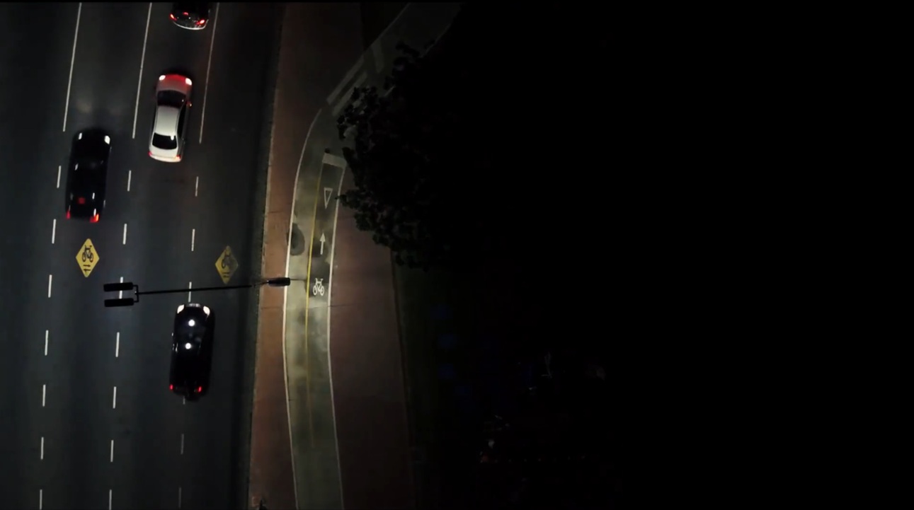 Remotely managed luminaire lighting the roadway and bike lane, aerial view